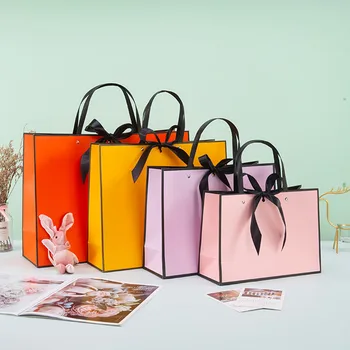 Şerit Yay ile toptan Kağıt Alışveriş Çantaları Geri Dönüşümlü Düğün hediye keseleri Perçin Kolları Giyim Kozmetik Takı Ambalaj Poşetleri